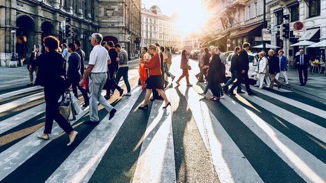 People crossing a city street. Photo by Jacek Dylag on Unsplash