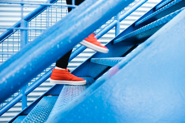 Person walking up stairs. Photo by Lindsay Henwood on Unsplash
