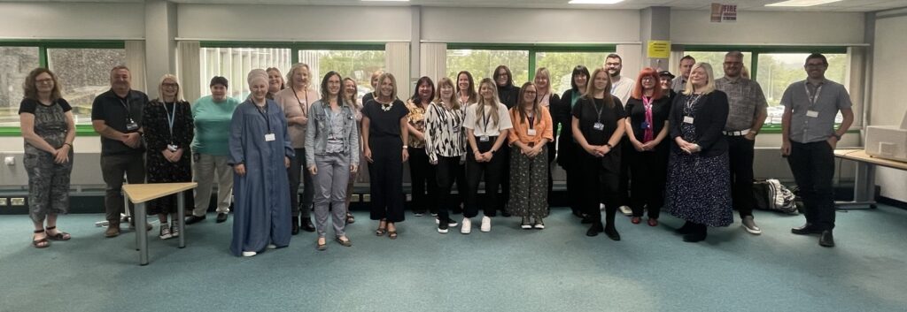 Fife Council Digital Champion networking event, June 2023. Photo is of about 30 Digital Champions standing in an open plan office area smiling