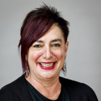 Headshot photo of Anna Fowlie - a woman with short dark hair smiles