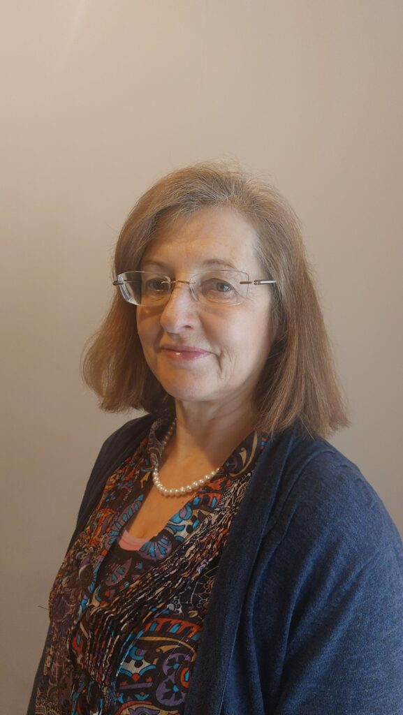 Headshot of Ruth Evans, a white middle-aged woman with brown hair and glasses.
