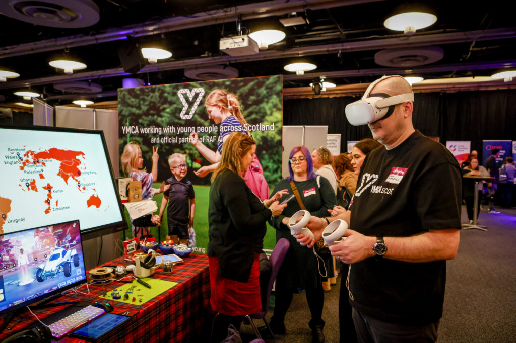 A delegate plays with a virtual reality headset in the Gathering exhibition.